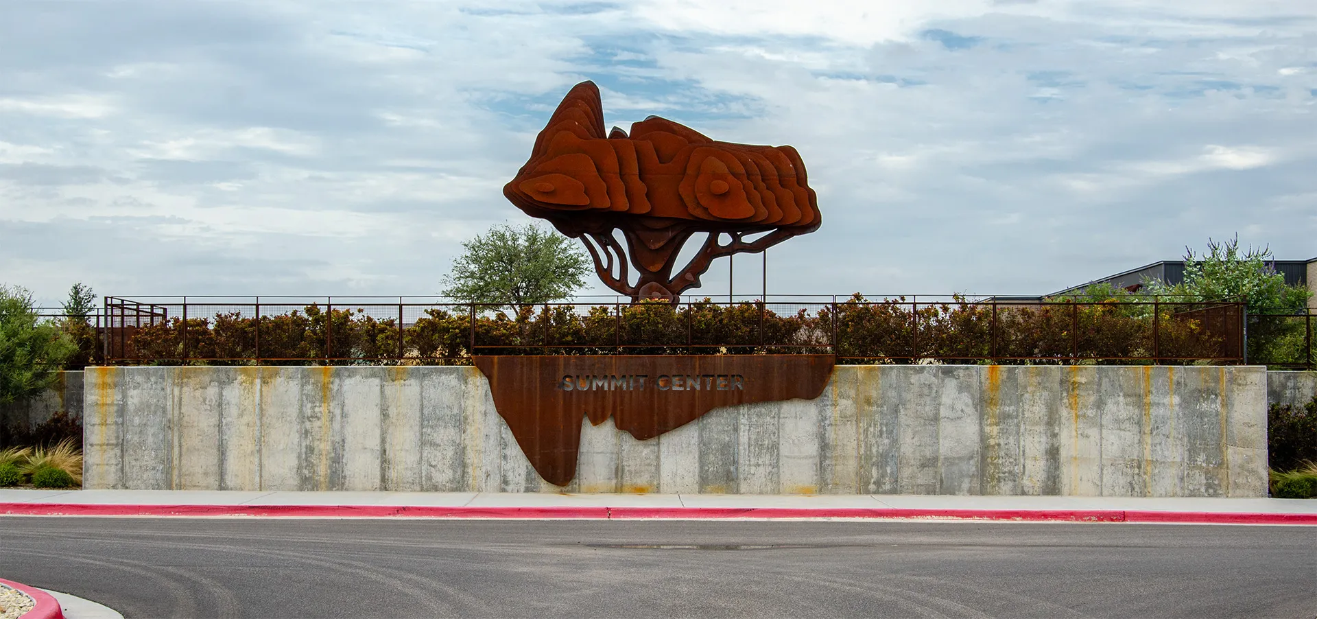 The Summit Center entrance sign, with a rusted steel tree sculpture above it